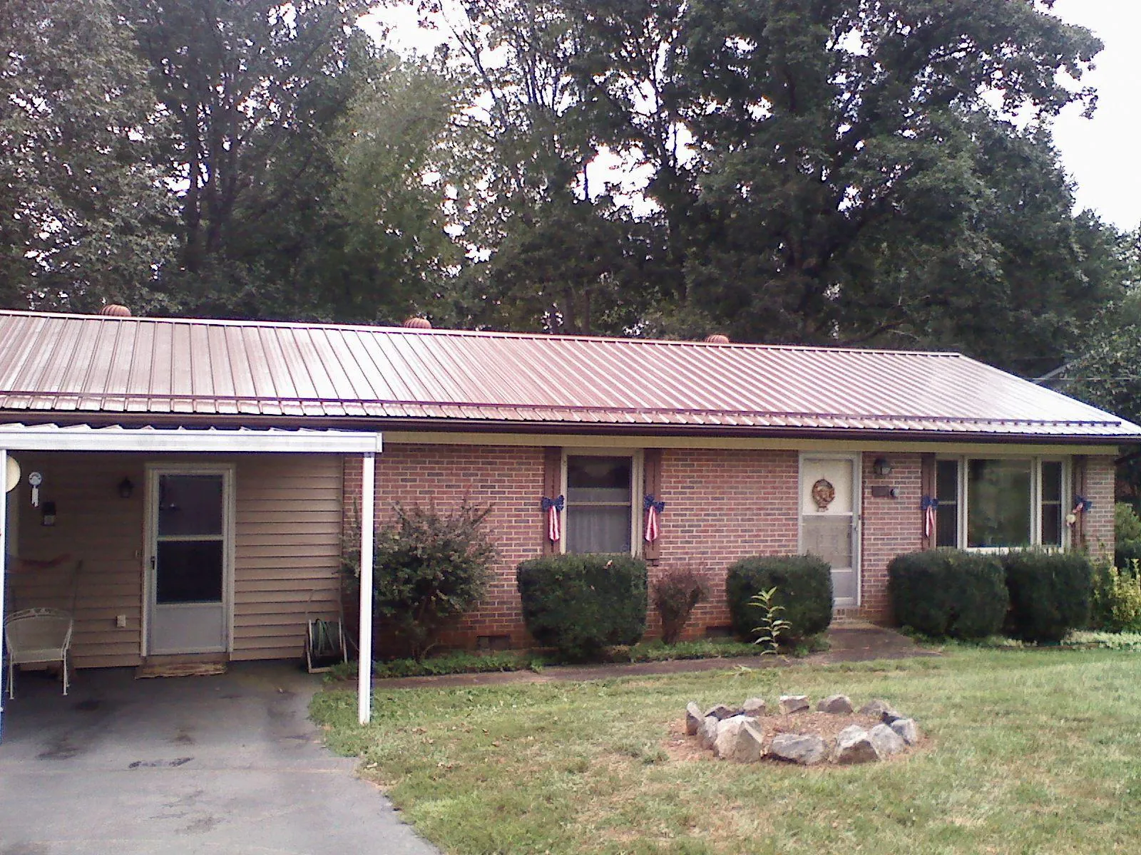 Bronze metal roof and carport on a brick ranch home — Roof Repair work by our crew in Verona